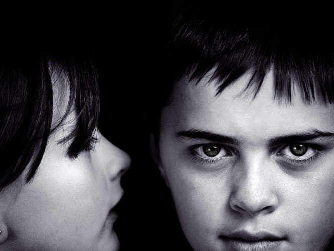 girl whispers to boy